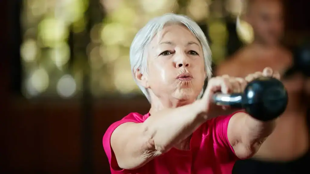 Toning Arms After 60: Empowering Womens Fitness Through Effective Weight Training 1 Older woman doing weight training Pinner to help her strength and longevity