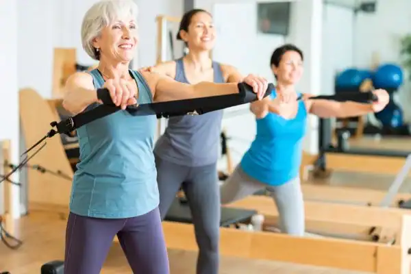 Toning Arms After 60: Empowering Womens Fitness Through Effective Weight Training 2 older woman doing weight training Pinner and resistance in the gym to tone upper arms